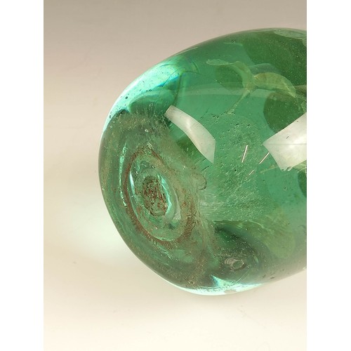 524 - Three Victorian green glass dump paperweights, late 19th century, each with floral inclusions in the... 