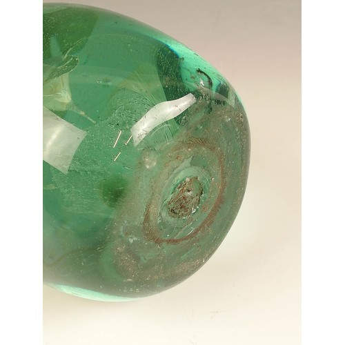 524 - Three Victorian green glass dump paperweights, late 19th century, each with floral inclusions in the... 