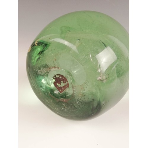 524 - Three Victorian green glass dump paperweights, late 19th century, each with floral inclusions in the... 