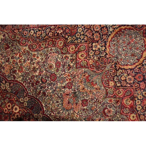 630 - A Persian pattern wool carpet, in red, white and green colourways, the all over foliate design with ... 