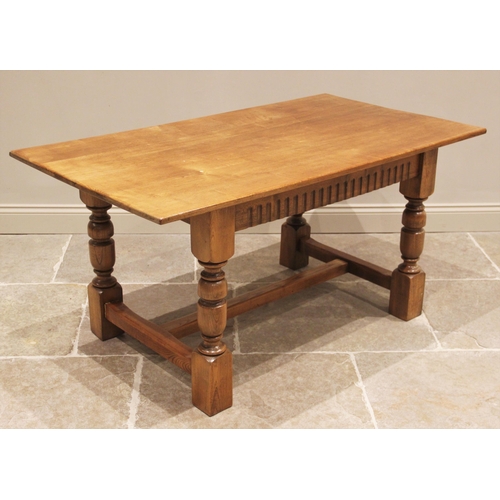 627 - A 17th century style honey oak refectory table, 20th century, the rectangular top above a nulled fri... 