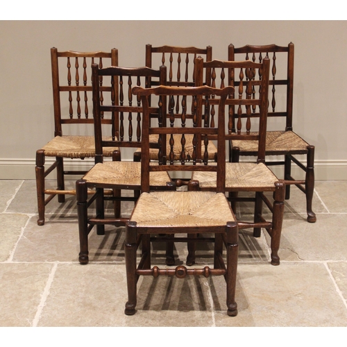 636 - A matched set of twelve ash and elm rush seat spindle back chairs, 19th century, each with two rows ... 