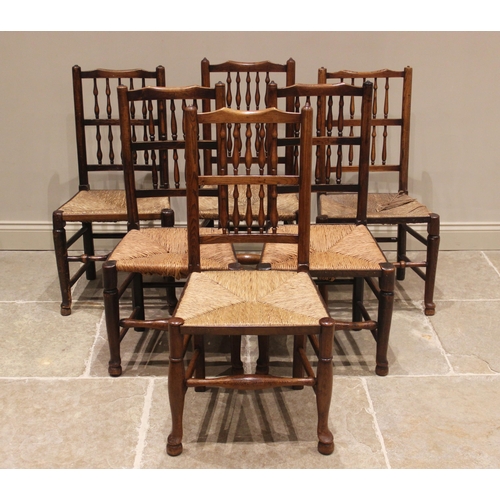 636 - A matched set of twelve ash and elm rush seat spindle back chairs, 19th century, each with two rows ... 