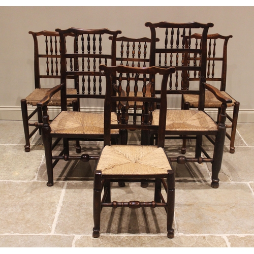 637 - A matched set of twelve ash and elm rush seat spindle back chairs, 19th century, each with a cupids ... 