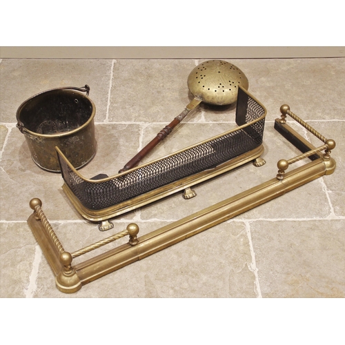 524 - A 19th century brass fire kerb with rope twist top rail, 124cm wide, a pierced and painted brass fen... 