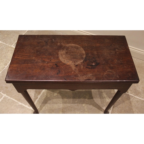 648 - A George III mahogany tea table, the rectangular folding top upon cylindrical tapering legs culminat... 