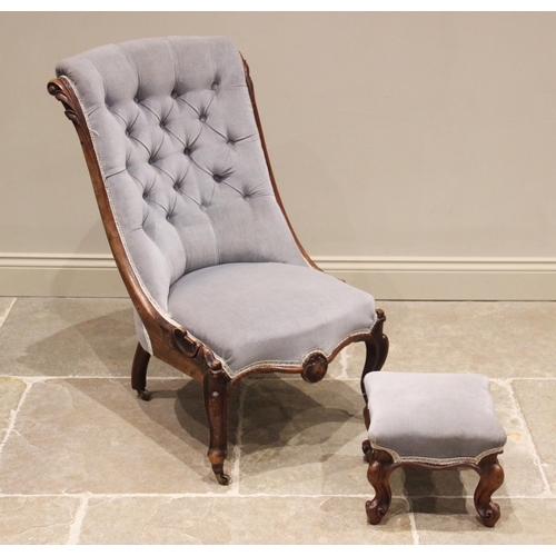 676 - A Victorian carved walnut button back salon chair, upholstered in blue velour, the button back frame... 