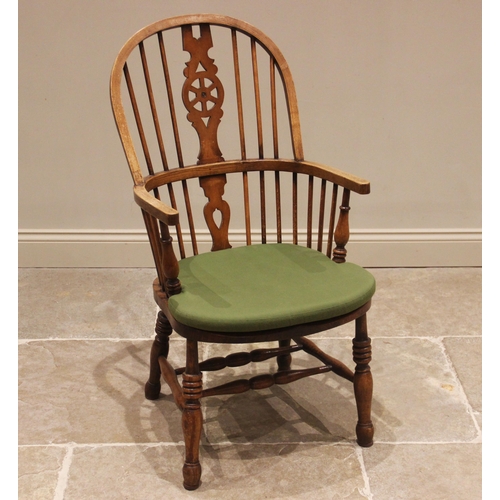 677 - A 19th century style ash and beech wheel back Windsor elbow chair, 20th century, with a hoop back an... 