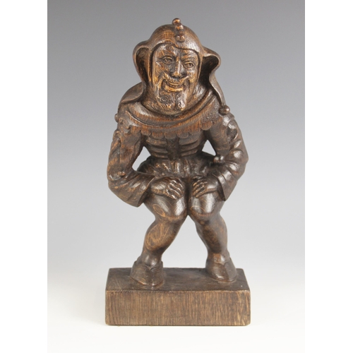 545 - A 17th century style carved oak figure of Rigoletto, 20th century, modelled in jester attire upon an... 