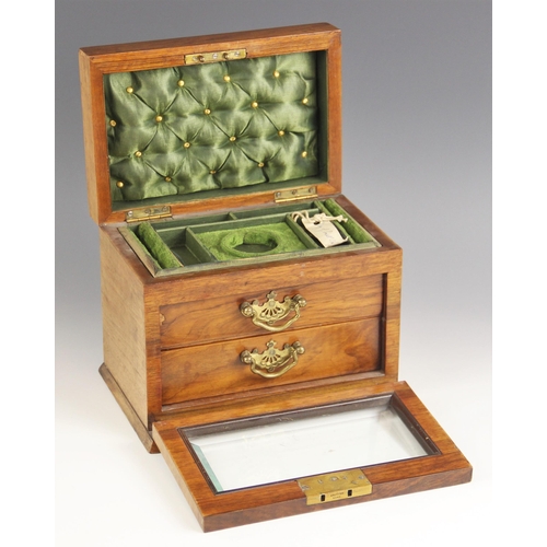 590 - An Edwardian walnut jewellery casket, the gently domed hinged cover with an inset swing handle, over... 