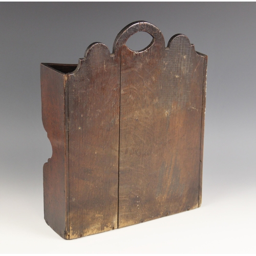 597 - An 18th century oak two tier candle box, probably Welsh, the shaped back with an almond shaped apert... 