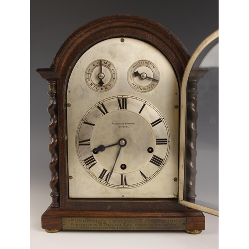 611 - A 1920's oak cased bracket clock retailed by Pleasance & Harper, Bristol, the arched case with barle... 