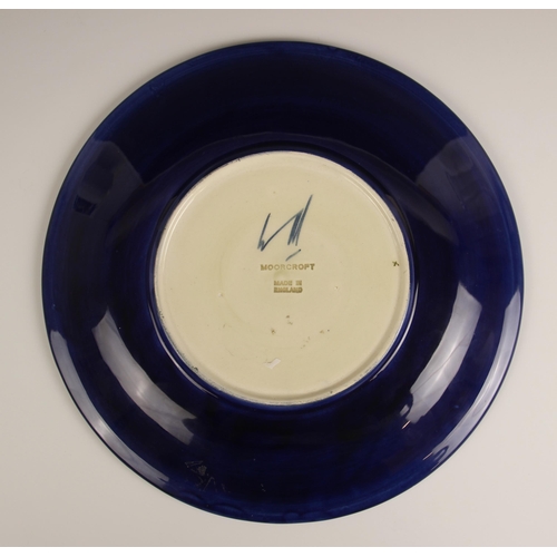 492 - A Moorcroft plate in the Hibiscus pattern against a cobalt blue ground, mid to late 20th century, im... 