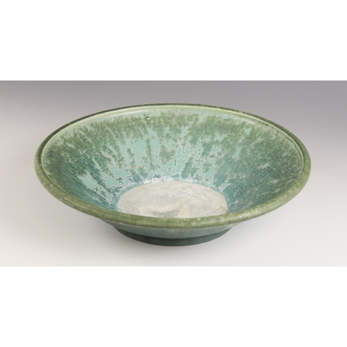 509 - A studio pottery bowl, 20th century, of shallow flared form with rolled rim, the celadon green groun... 