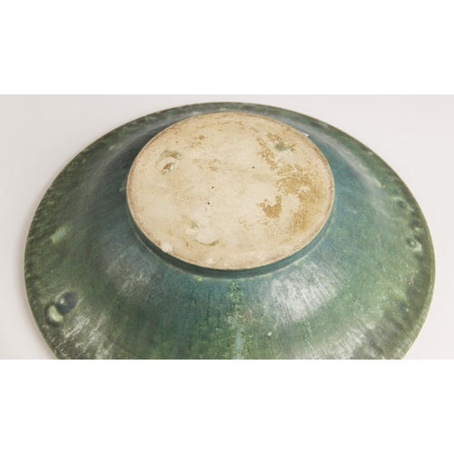 509 - A studio pottery bowl, 20th century, of shallow flared form with rolled rim, the celadon green groun... 