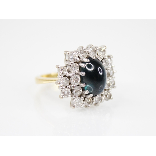 166 - A sapphire and diamond cluster ring, the central oval sapphire cabochon measuring 11mm x 7.5mm, with... 