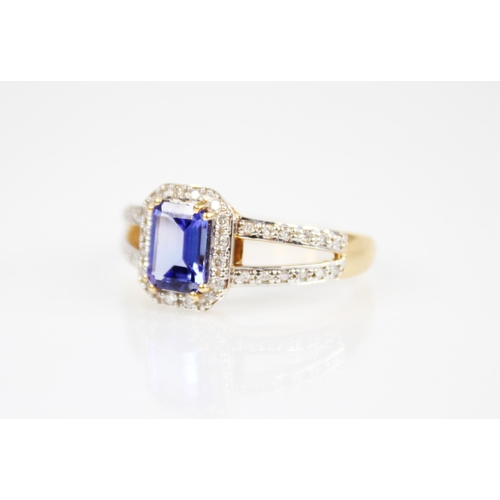 209 - A tanzanite and diamond 18ct gold ring, the central emerald cut tanzanite measuring 8mm x 6mm, withi... 