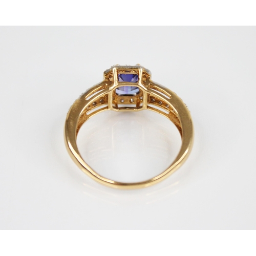 209 - A tanzanite and diamond 18ct gold ring, the central emerald cut tanzanite measuring 8mm x 6mm, withi... 