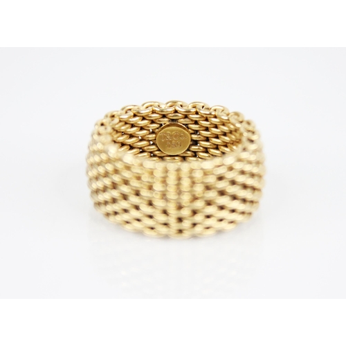 244 - An 18ct gold mesh-link ring, applied pad to interior stamped 'T&CO 750', 11mm wide, ring size P, wei... 