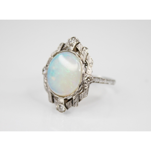 245 - An Art Deco style opal and diamond ring, the central oval opal cabochon measuring 13mm x 11mm, set t... 