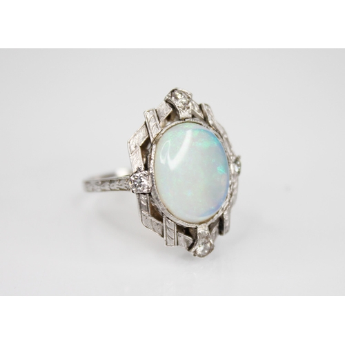 245 - An Art Deco style opal and diamond ring, the central oval opal cabochon measuring 13mm x 11mm, set t... 