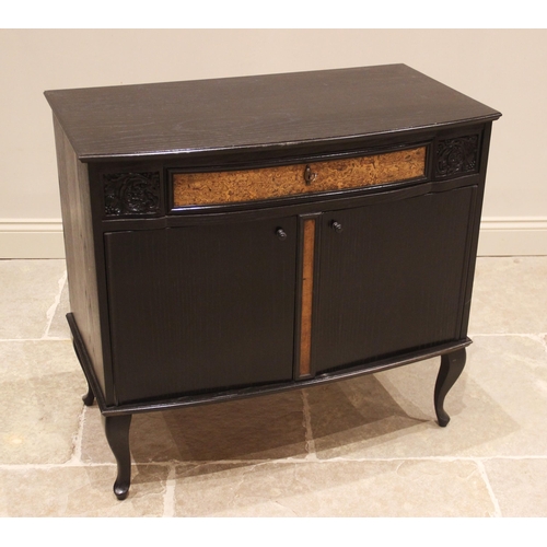 705 - A continental ebonised music cabinet, mid to late 20th century, the moulded bowfront top over a sing... 