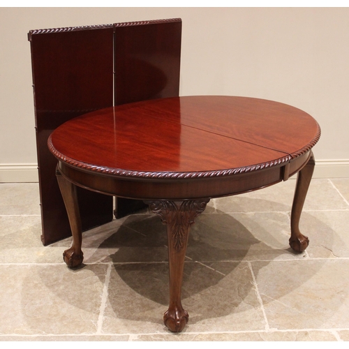 688 - A Chippendale revival mahogany dining table, circa 1920, the extending oval top with a gadroon borde... 