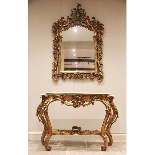 689 - A Rococo revival giltwood and gesso marble top console table and mirror, mid 20th century, the arche... 