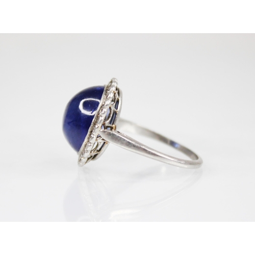 192 - An early 20th century sapphire and diamond cluster ring, the central oval sapphire cabochon measurin... 