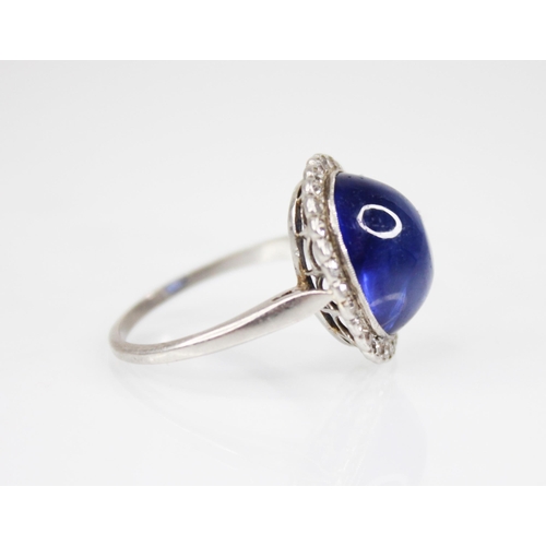 192 - An early 20th century sapphire and diamond cluster ring, the central oval sapphire cabochon measurin... 