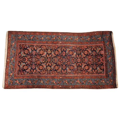 579 - A Persian pattern wool rug in red, blue and green colourways, the all over foliate design enclosed b... 