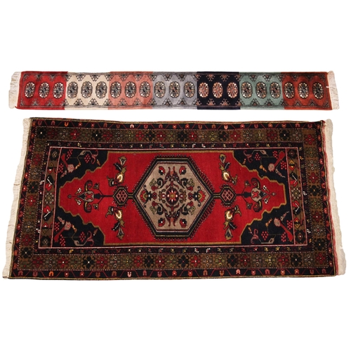 583 - A Caucasian wool rug, in red, blue and yellow colourways, the central hexagonal medallion upon a vib... 