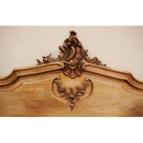 690 - A Louis XV style walnut bed, early 20th century, of serpentine form with carved rocaille detail, upo... 