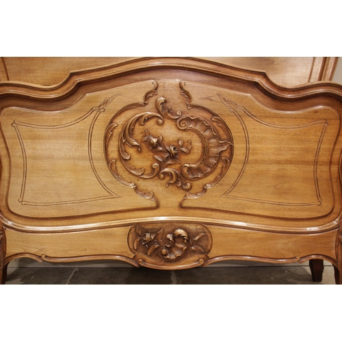 690 - A Louis XV style walnut bed, early 20th century, of serpentine form with carved rocaille detail, upo... 