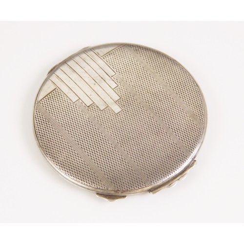 83 - A George VI Art Deco silver compact, W I Broadway & Co, Birmingham 1946, of circular form with engin... 