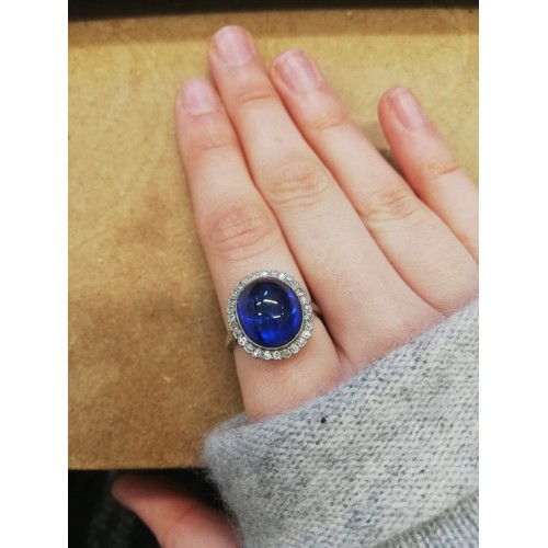 192 - An early 20th century sapphire and diamond cluster ring, the central oval sapphire cabochon measurin... 