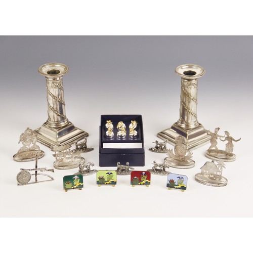 104A - A selection of novelty place card holders, to include five Burmese silver coloured examples, modelle... 