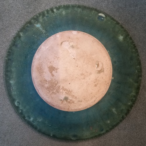 509 - A studio pottery bowl, 20th century, of shallow flared form with rolled rim, the celadon green groun... 