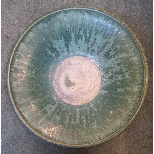 509 - A studio pottery bowl, 20th century, of shallow flared form with rolled rim, the celadon green groun... 