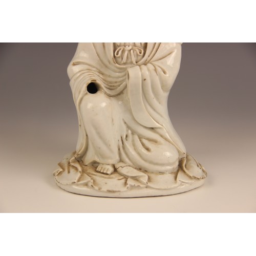 424 - A Chinese Blanc de chine porcelain figure of Guanyin, 19th century, modelled kneeling and wearing a ... 