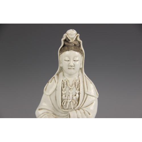 424 - A Chinese Blanc de chine porcelain figure of Guanyin, 19th century, modelled kneeling and wearing a ... 