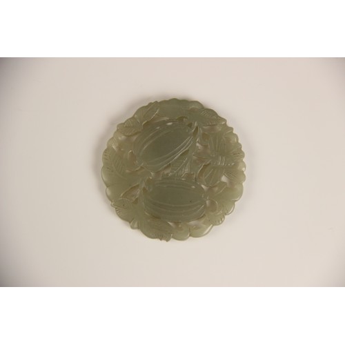 413 - A Chinese jade roundel, of reticulate circular form, carved with vines and two fruiting gourds with ... 