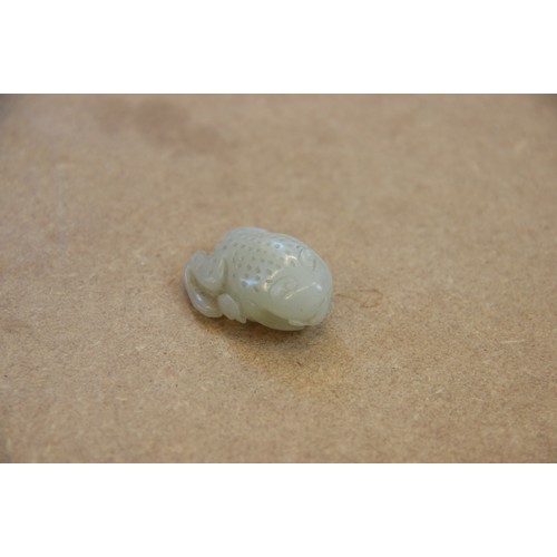 427 - A Chinese pale jade toad, 19th century, the celadon coloured carving modelled grasping a fruiting vi... 