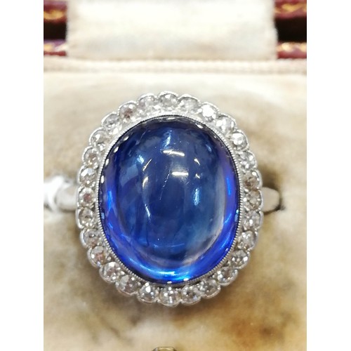 192 - An early 20th century sapphire and diamond cluster ring, the central oval sapphire cabochon measurin... 