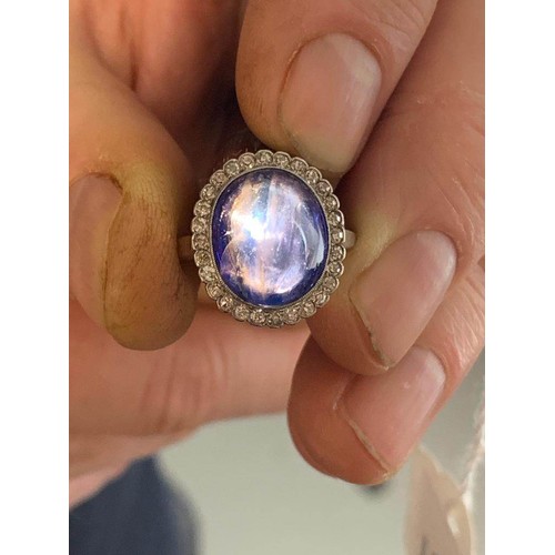 192 - An early 20th century sapphire and diamond cluster ring, the central oval sapphire cabochon measurin... 