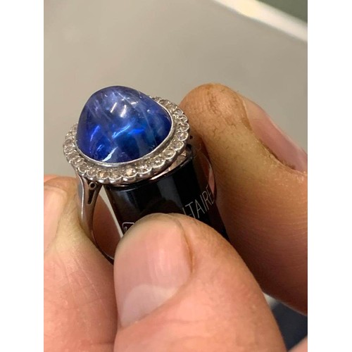 192 - An early 20th century sapphire and diamond cluster ring, the central oval sapphire cabochon measurin... 