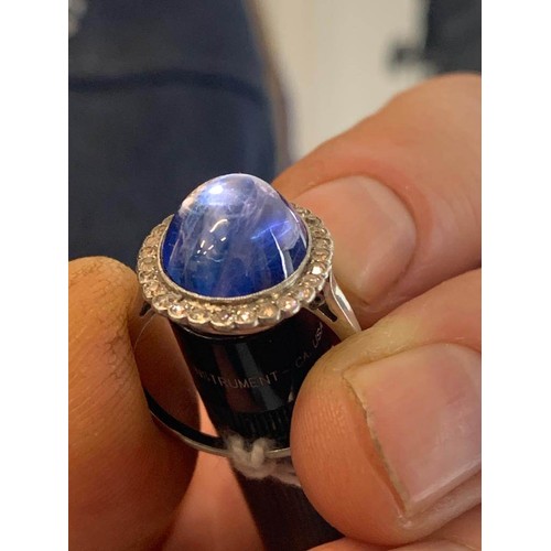 192 - An early 20th century sapphire and diamond cluster ring, the central oval sapphire cabochon measurin... 