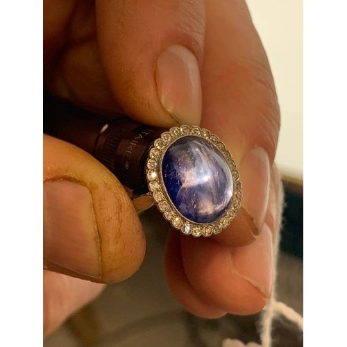 192 - An early 20th century sapphire and diamond cluster ring, the central oval sapphire cabochon measurin... 