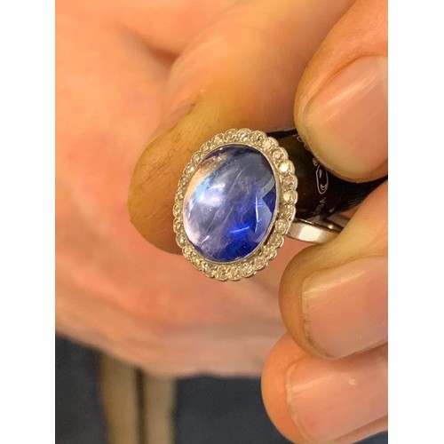 192 - An early 20th century sapphire and diamond cluster ring, the central oval sapphire cabochon measurin... 