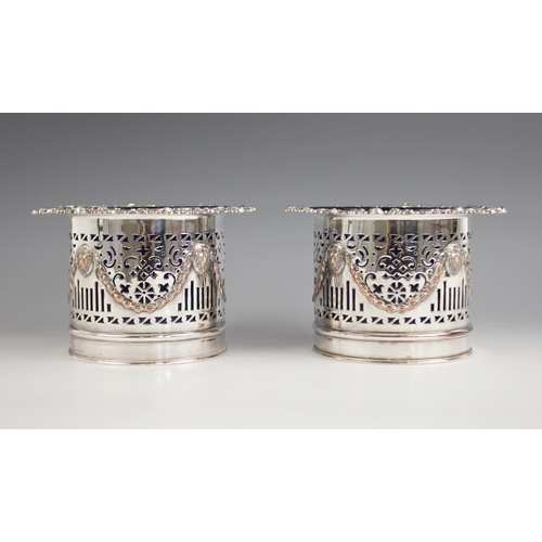 124 - A pair of early 20th century silver plated bottle coasters, each of cylindrical form with lion masks... 